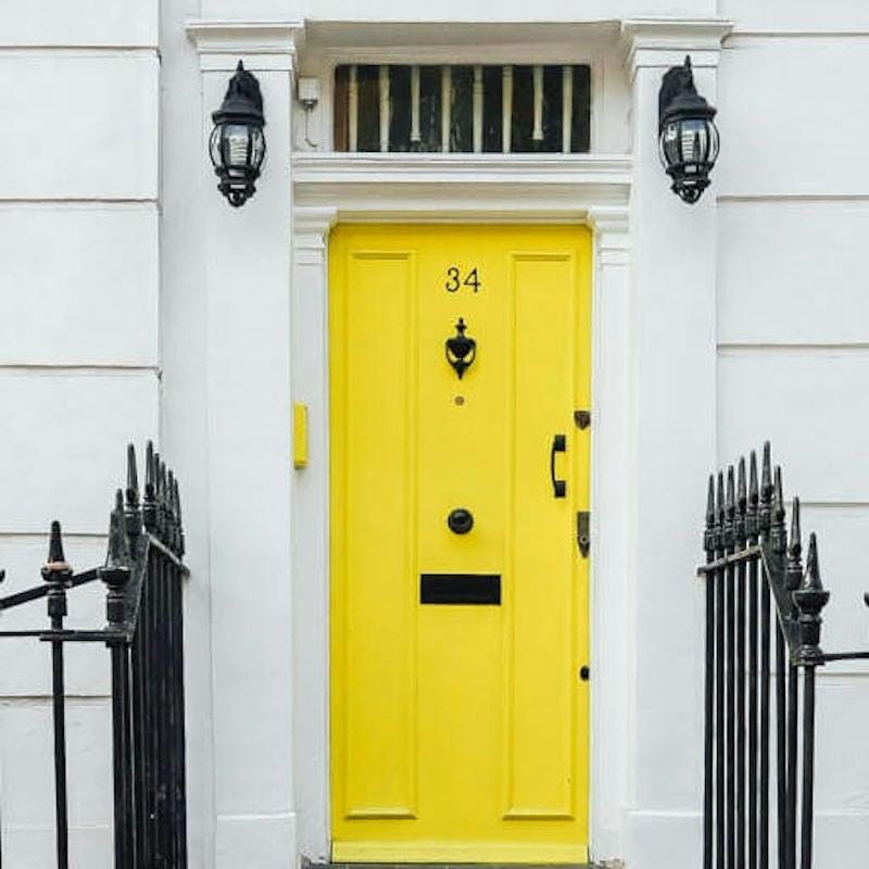 casa blanca con puerta amarilla