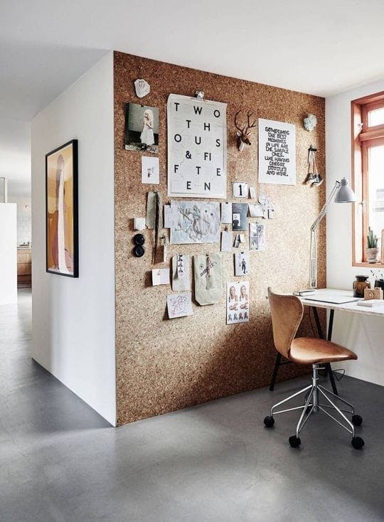 Un espacio de trabajo con una pared de corcho con un vision board