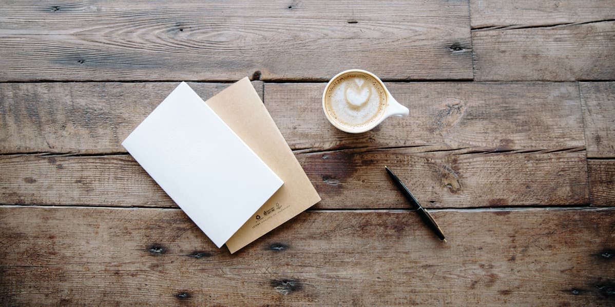 carta en blanco en una mesa de madera y café