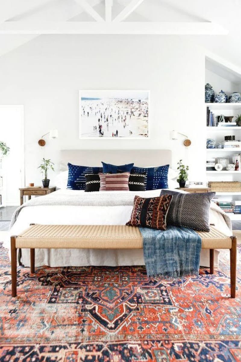 Dormitorio en tonos claros con alfombra persa