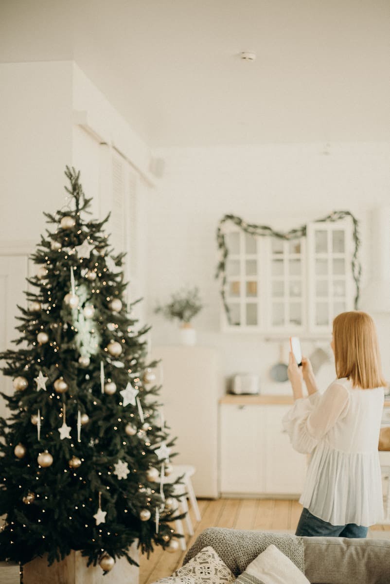 chica sacando foto a su árbol de Navidad