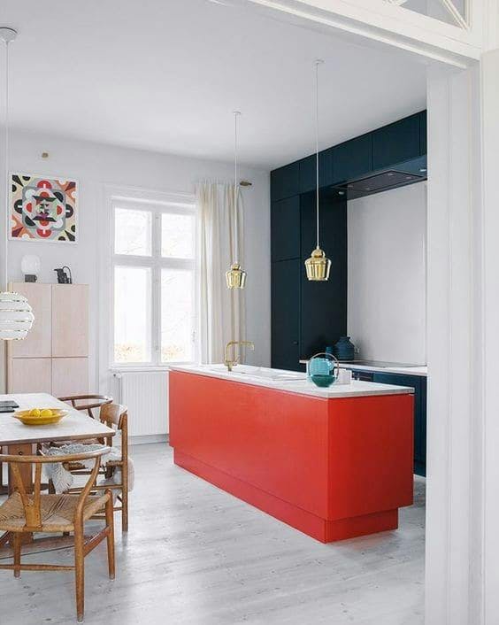 Cocina con pared oscura y mueble rojo