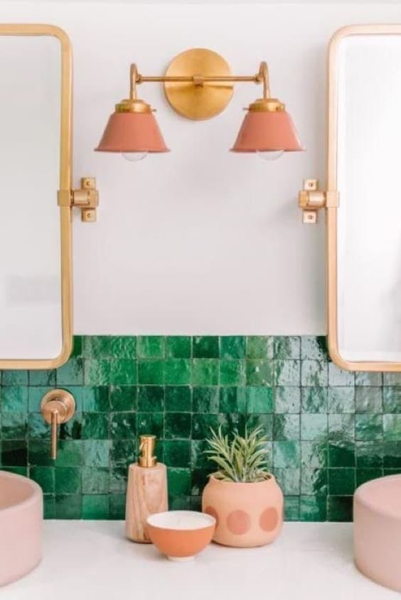 Baño con azulejo verde y lavabos rosa